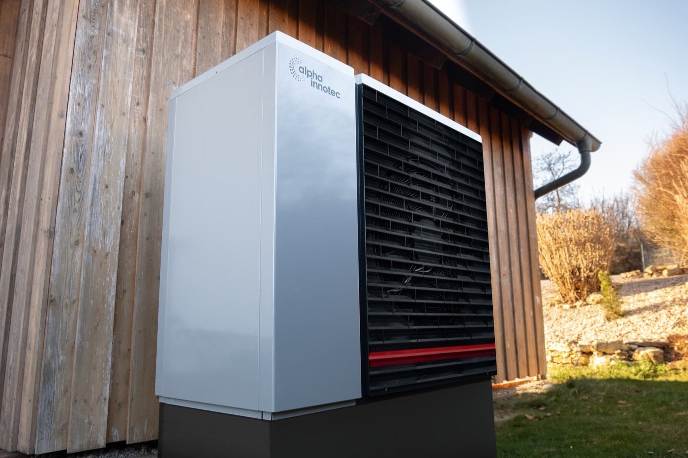 Pompa di calore accanto a una facciata in legno