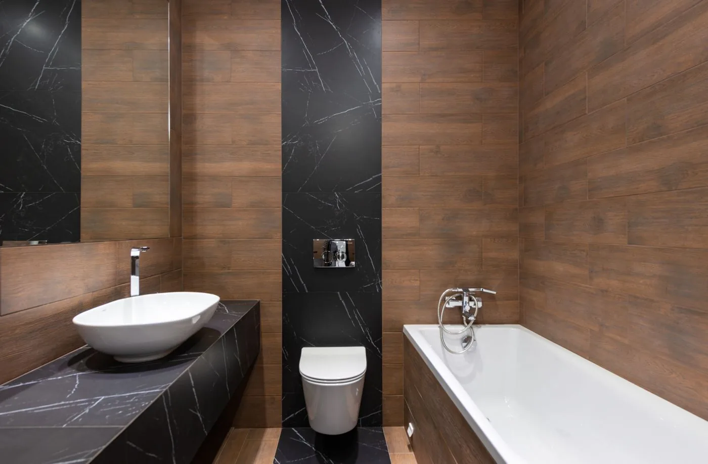 Waschplatz und Badewanne mit dunklen Holzflächen