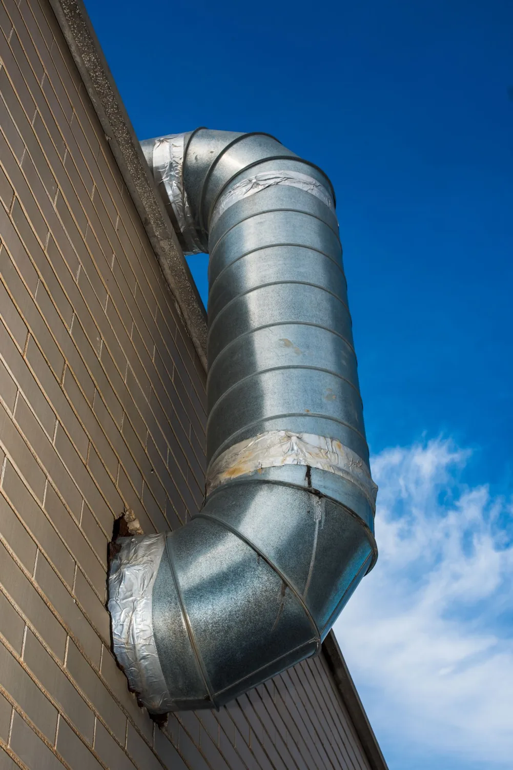 手入れされた建物の外壁にある丸い換気ダクト