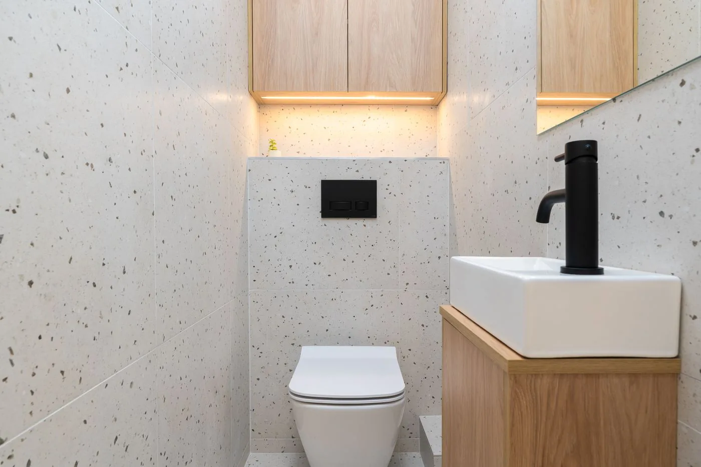 Gäste-WC mit schwarzer Armatur und hellem Holz