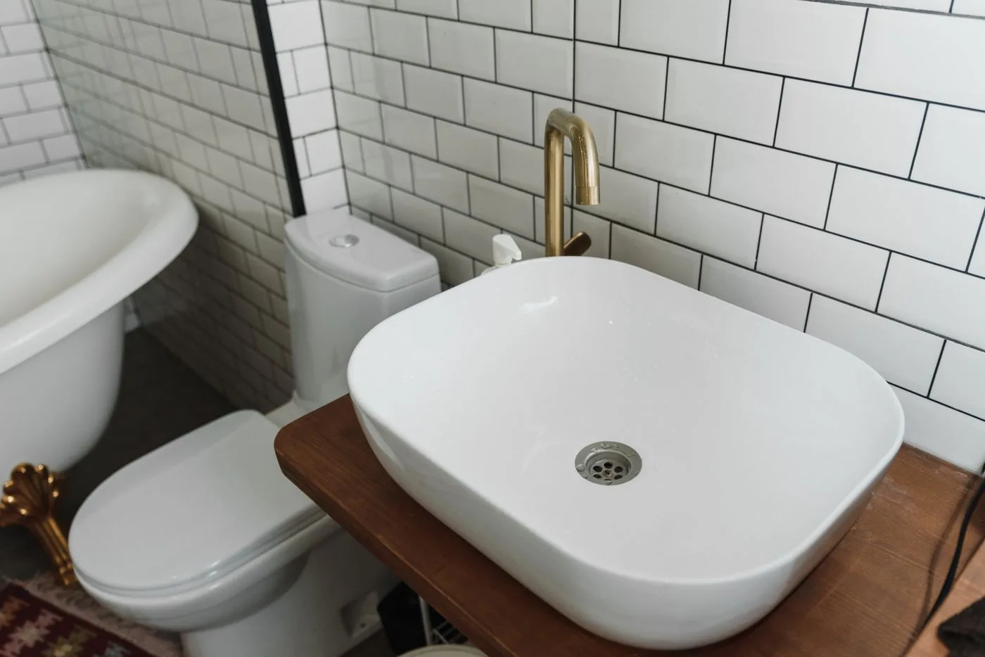 Aufsatzwaschbecken mit goldfarbener Armatur