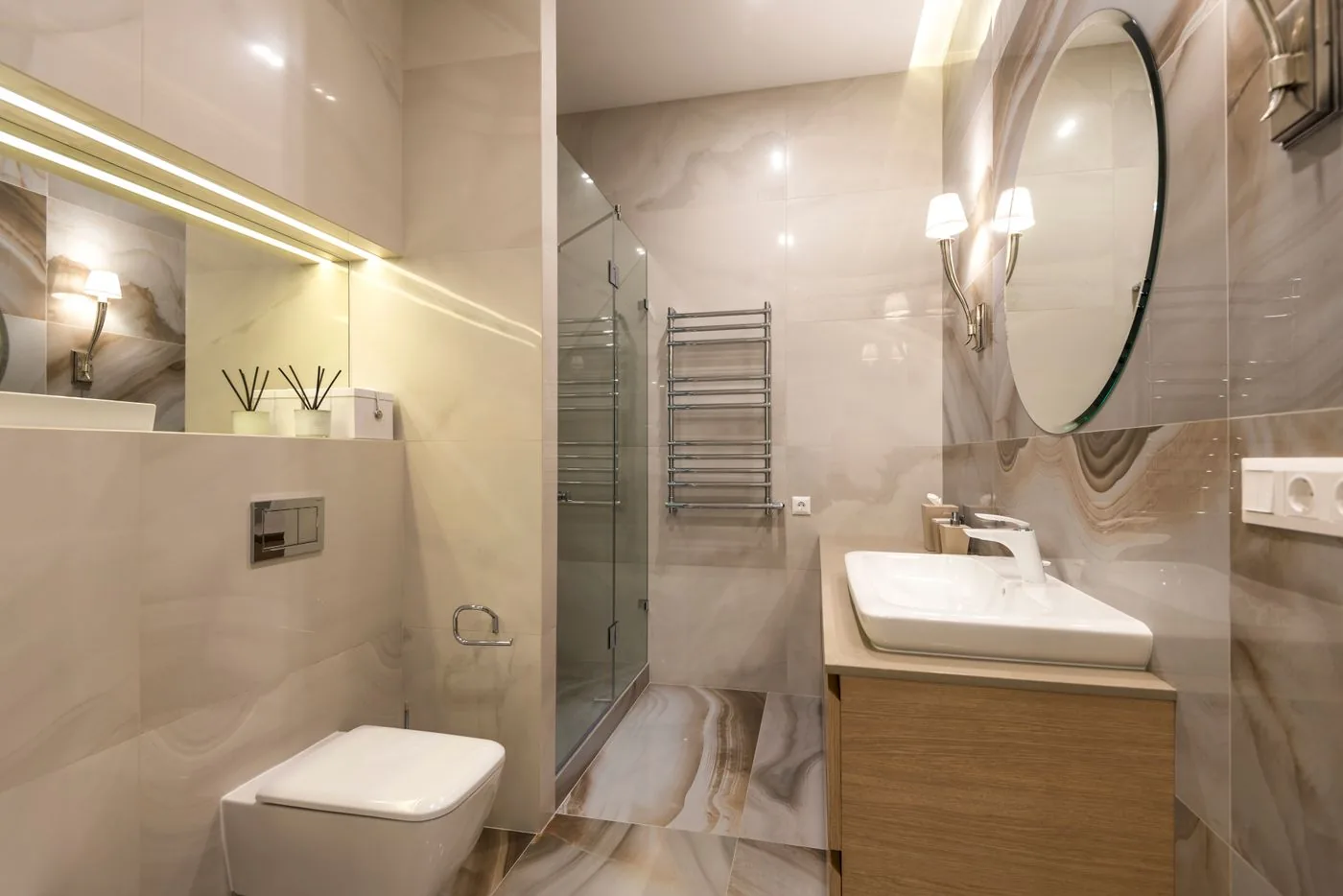 Kamar mandi ringkas dengan cermin bundar dan radiator handuk