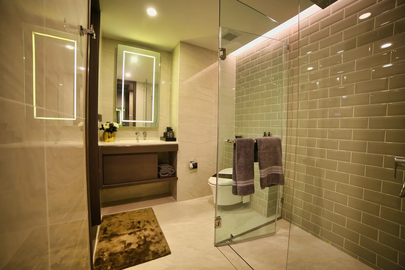 Kamar mandi dengan pancuran kaca dan cermin berlampu